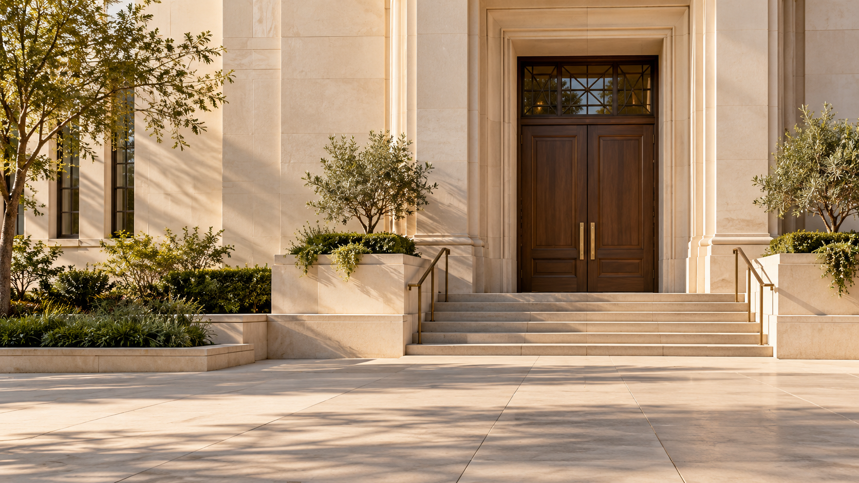 Stone steps leading to dark wood courthouse doors, framed by warm limestone and greenery.